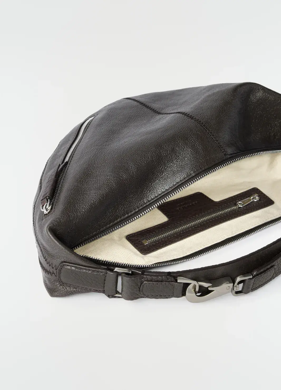 A small black leather shoulder bag on a pale studio background
